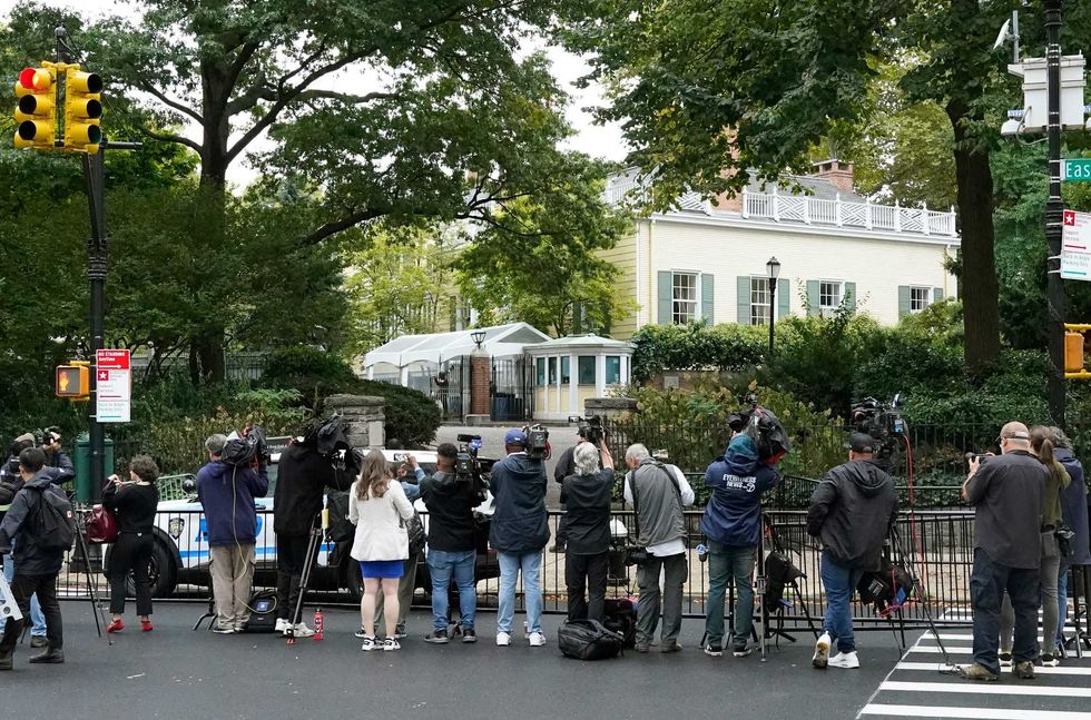 Reporters stand outside Gracie Mansion, the official residence of the mayor of New York City, on September 26, 2024