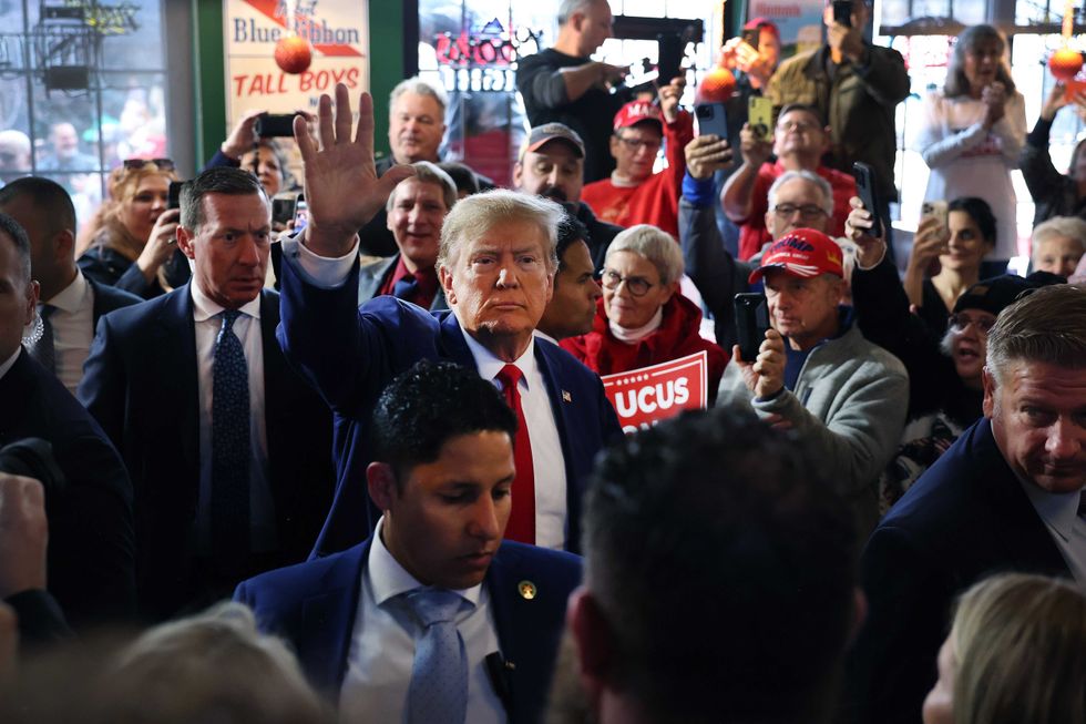 Republican presidential candidate Donald Trump greets guests as he arrives at a commit to caucus campaign event at the Whiskey River bar on Dec. 2, 2023, in Ankeny, Iowa