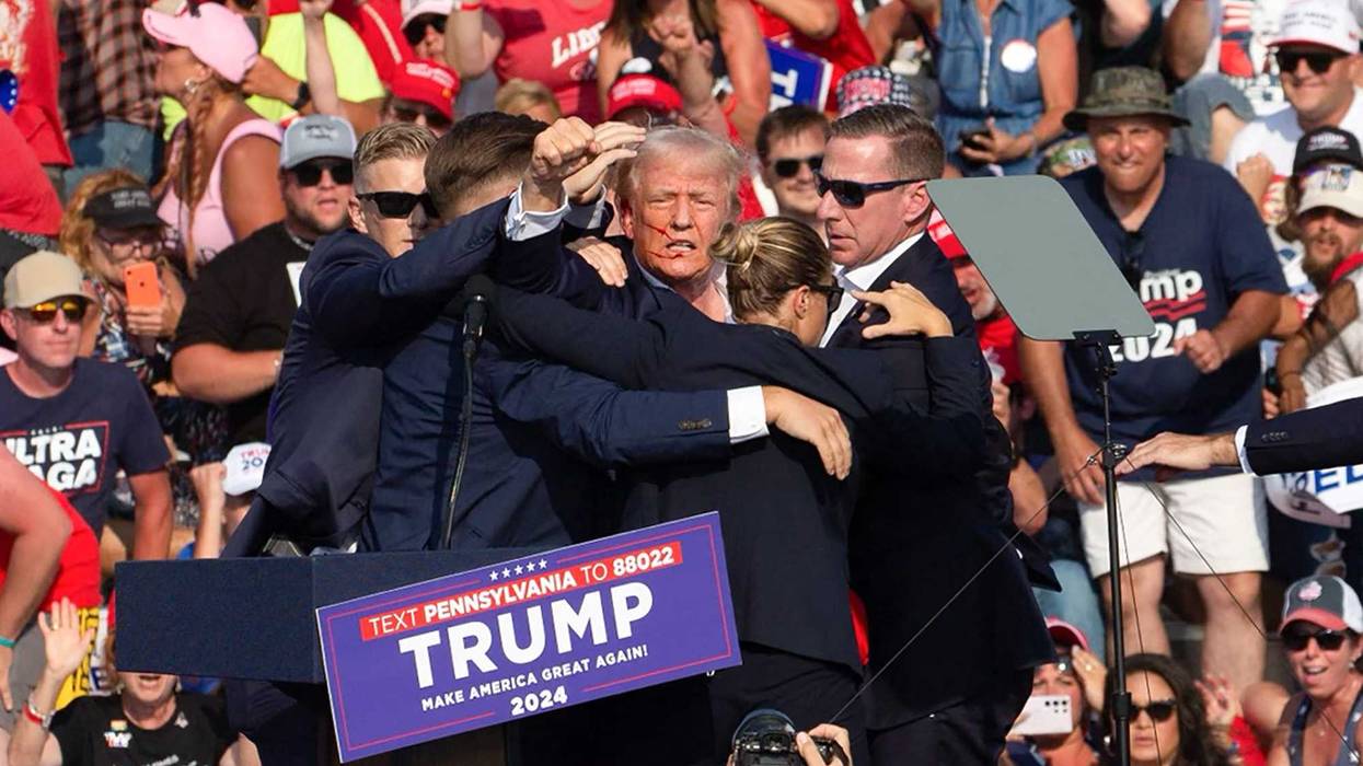 Republican presidential candidate Donald Trump is seen with blood on his face, surrounded by secret service agents, as he is taken off the stage at a campaign event in Butler, Pa., on July 13, 2024.
