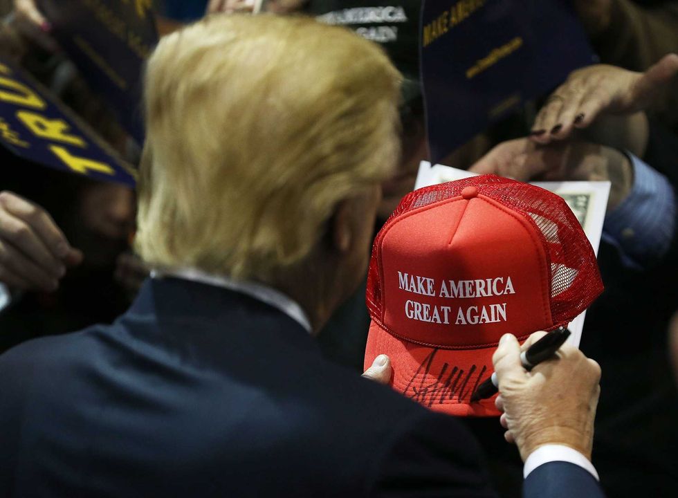 Republican presidential candidate Donald Trump signs one of his campaign hats during a event at the University of Northern Iowa on January 12, 2016 in Cedar Falls, Iowa. Trump continues his quest to become the Republican presidential nominee.