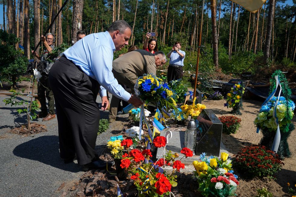 Republican presidential candidate former New Jersey Gov. Chris Christie participates in a flowers laying ceremony as he visits a former defence line from Russian massive offensive in March 2022 in the village of Moshchun, outskirts of Kyiv, Ukraine, Friday, Aug. 4, 2023