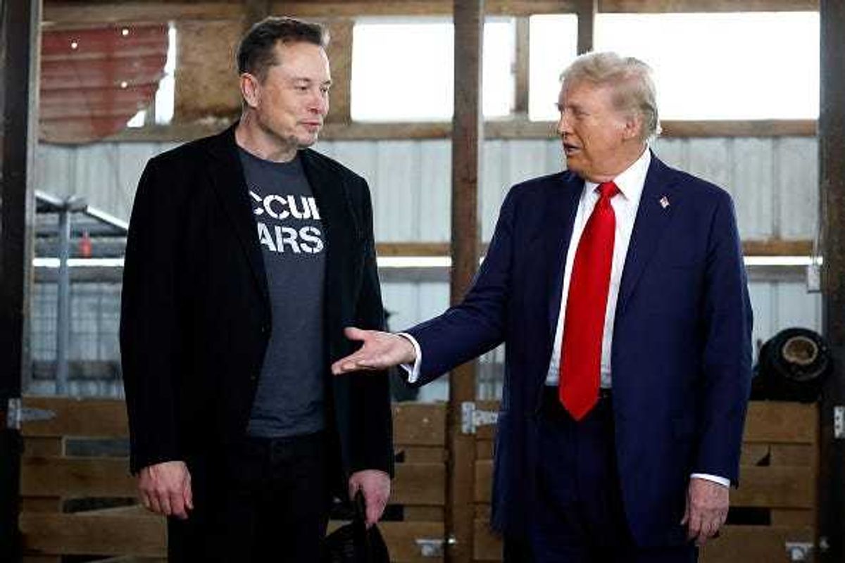 Republican presidential nominee, former President Donald Trump offers his hand to Elon Musk back stage during a campaign rally at the Butler Farm Show grounds on October 05, 2024 in Butler, Pennsylvania.