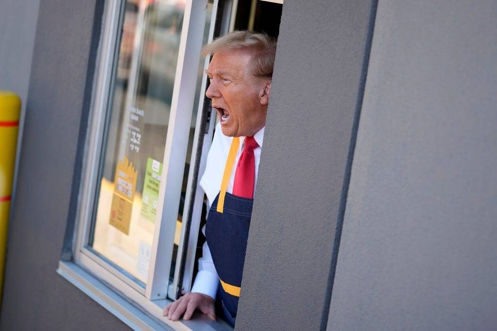 Republican presidential nominee former President Donald Trump speaks while standing at a drive-thru window during a campaign stop at a McDonald