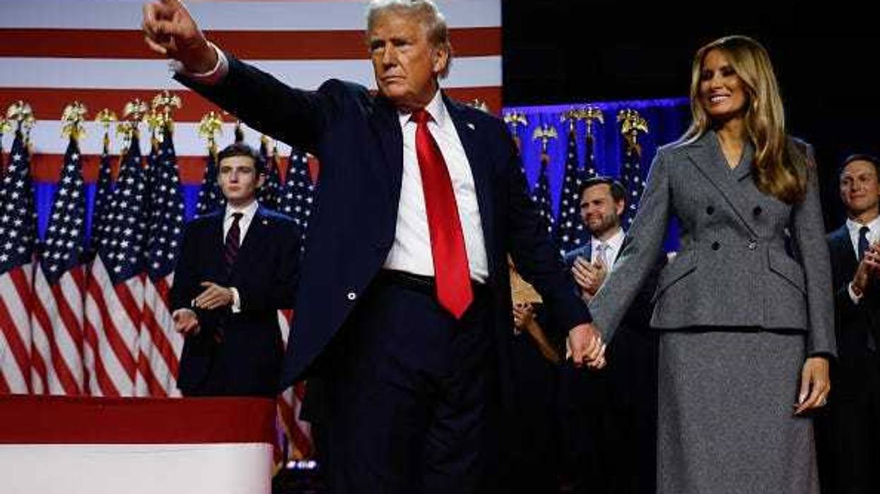 Republican presidential nominee, former U.S. President Donald Trump points to supporters with former first lady Melania Trump during an election night event at the Palm Beach Convention Center on November 06, 2024 in West Palm Beach, Florida.