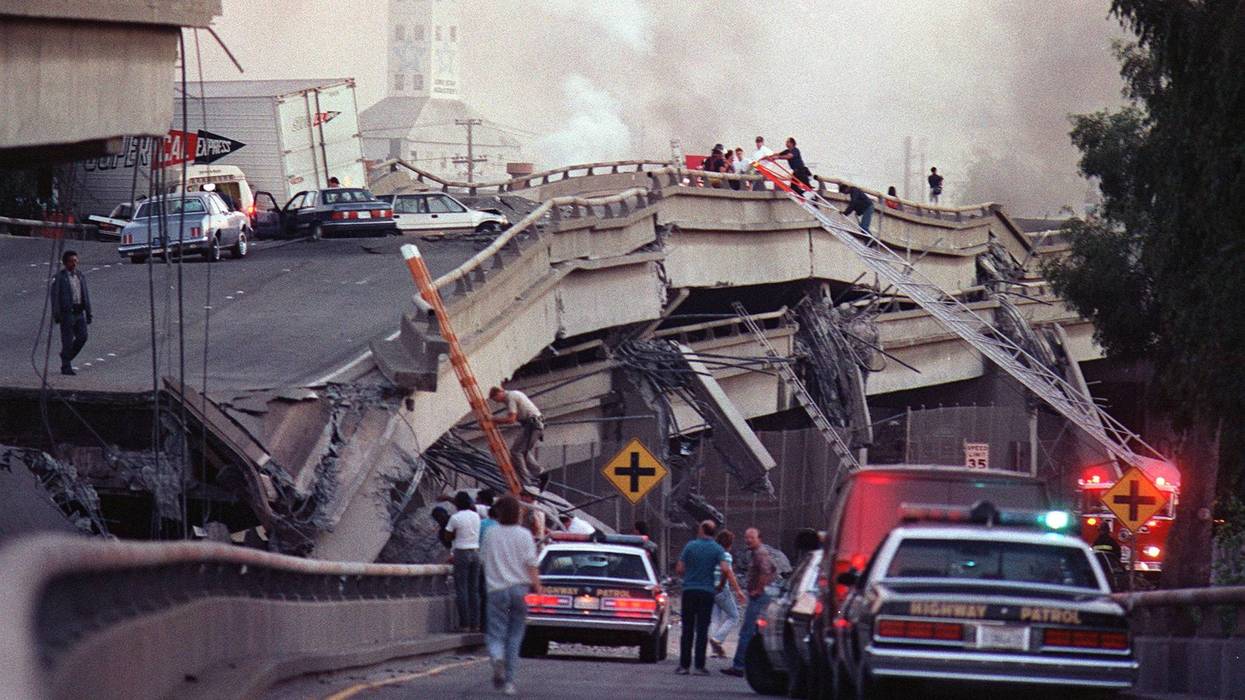 Rescue workers and police enter the scene of destruction where the Interstate 880-Interstate 80 interchange collapsed in Oakland during the Loma Prieta earthquake in October 1989.