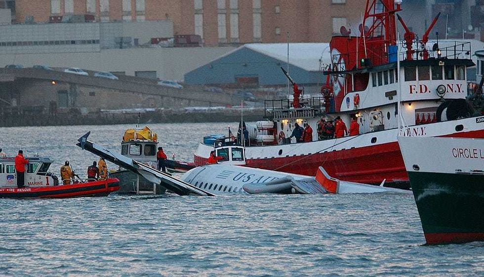 Rescue workers assist a New York City Fire Department boat pulled near a US Airways plane floating in the water after crashing into the Hudson River in the afternoon on Jan. 15, 2009.