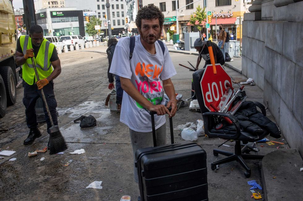 Residents of a homeless encampment prepare to move their belongings as workers from the city prepare to clean up the area in a city sweep ordered by Mayor Adams, September 22, 2022.
