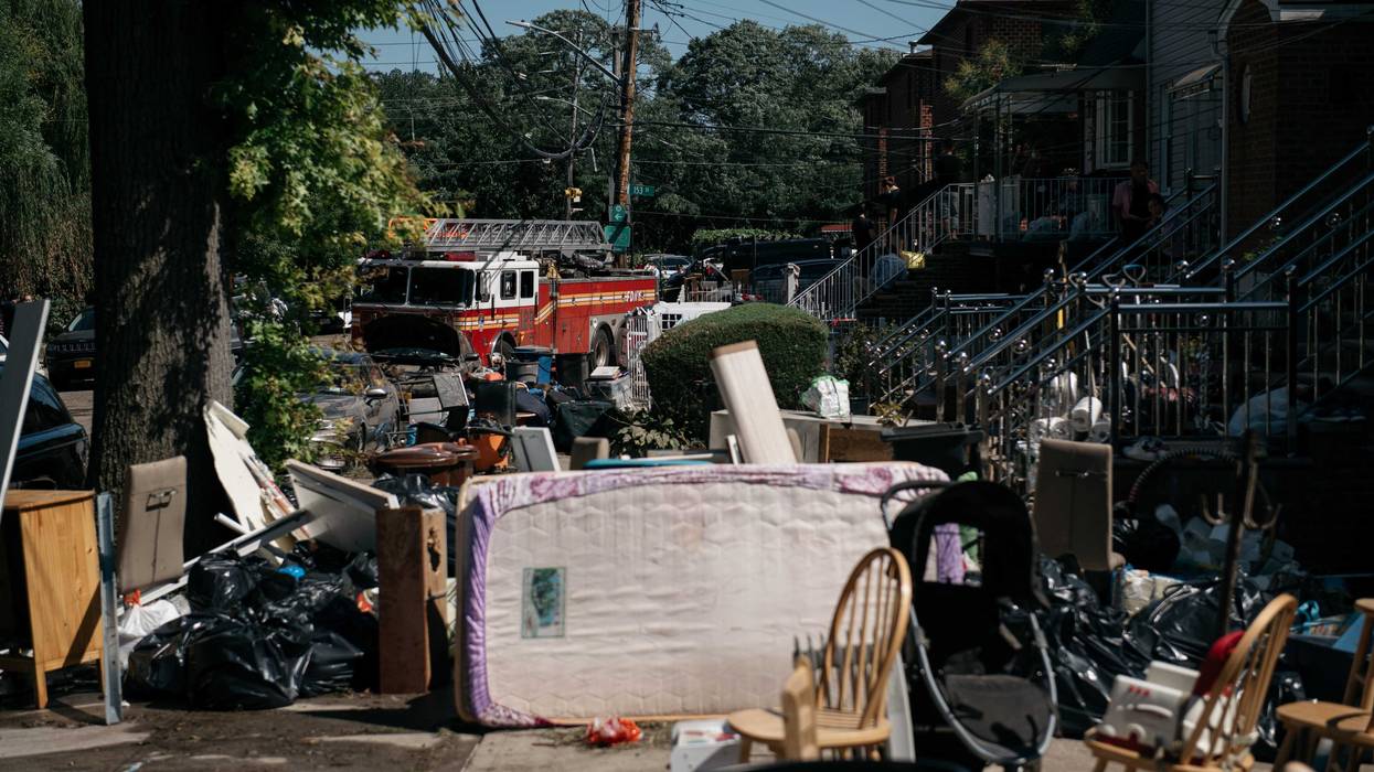 Residents sort through damaged and destroyed items after a night of heavy rain and wind caused many homes to flood on September 2, 2021 in the Flushing neighborhood of the Queens