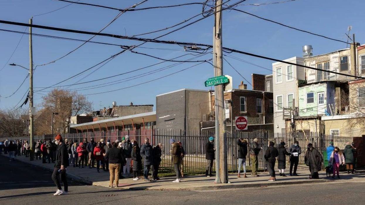 Residents wait in line to receive free rapid at-home COVID-19 test kits at a vaccine clinic in Philadelphia, Dec. 20, 2021.