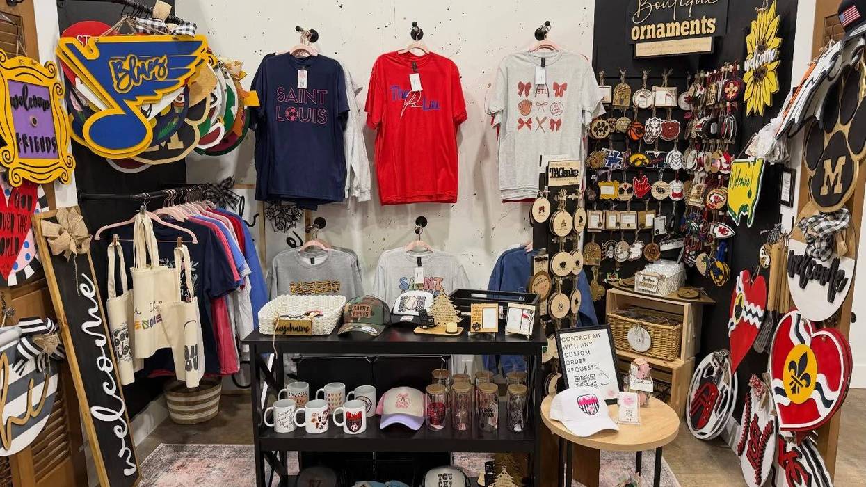 Retail booth displaying St. Louis themed shirts, ornaments, and various home decor items.