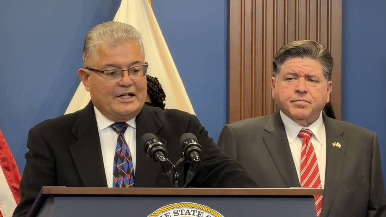 Retired federal judge Ruben Castillo, the chair of the Illinois Accountability Commission, discusses the panel's findings, as Gov. J.B. Pritzker looks on.