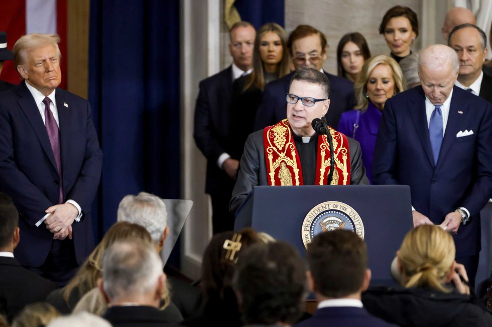 Rev. Father Frank Mann (C) of the Roman Catholic Diocese of Brooklyn delivers a benediction as US President Donald Trump (L) and former US President Joe Biden (R) listen during Trump