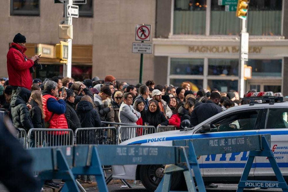 Revelers wait in line on Sixth Avenue to clear security prior to entering Times Square on December 31, 2024.