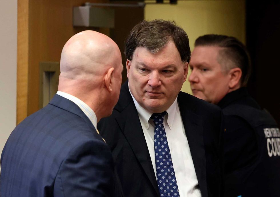 Rex A. Heuermann speaks with his lawyer Michael Brown during a court hearing where he was charged in the killing of Valerie Mack, inside Supreme Court Justice Timothy Mazzei