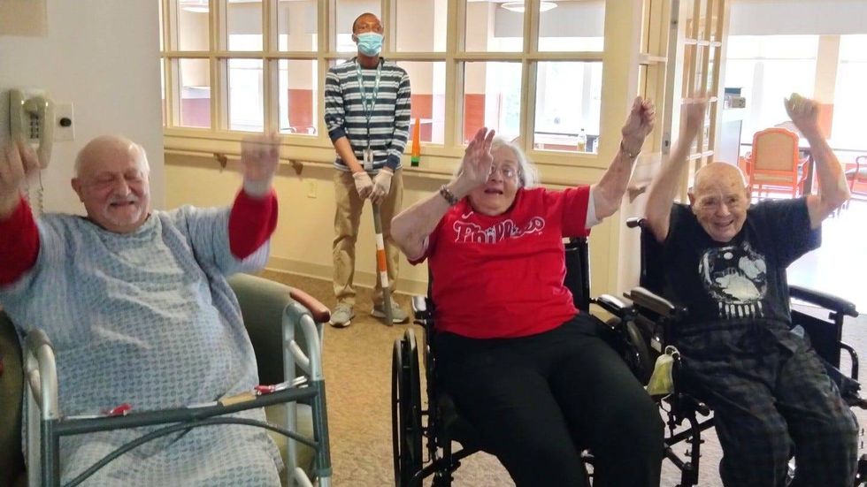 Rhoda Cohen demonstrates the wave with her friends at the Horsham Center for Jewish Life.