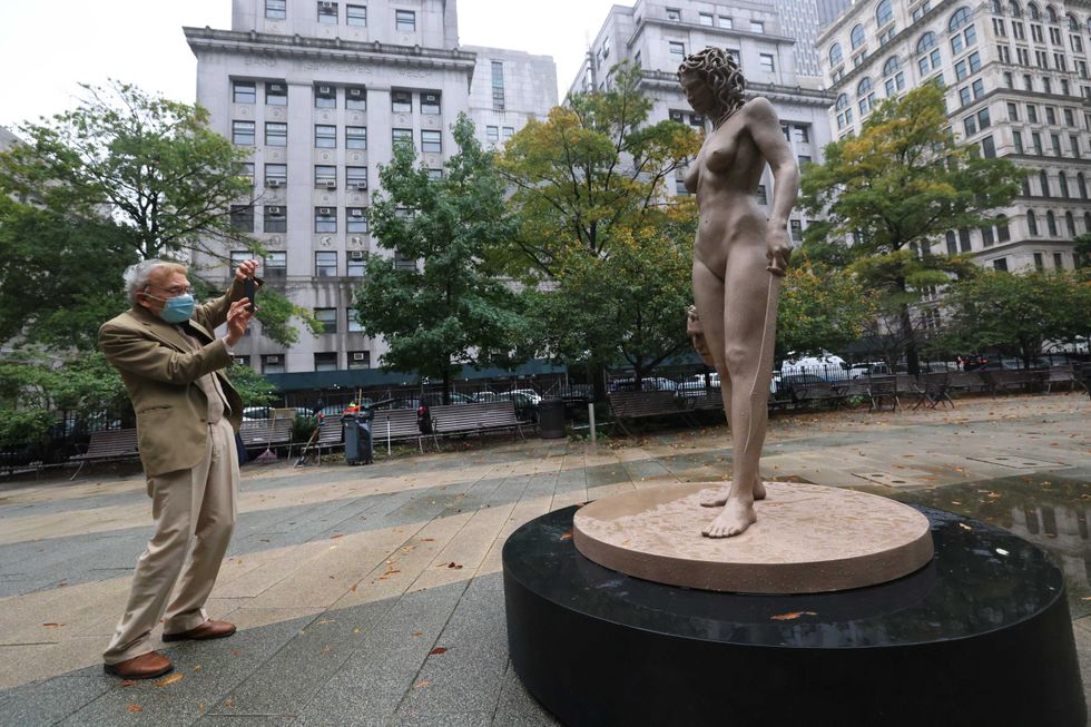 Richard Lewkowicz takes a photo of the newly installed statue of "Medusa With The Head of Perseus" by Argentine-Italian artist Luciano Garbati stands in Collect Pond Park on October 13, 2020 in New York City.