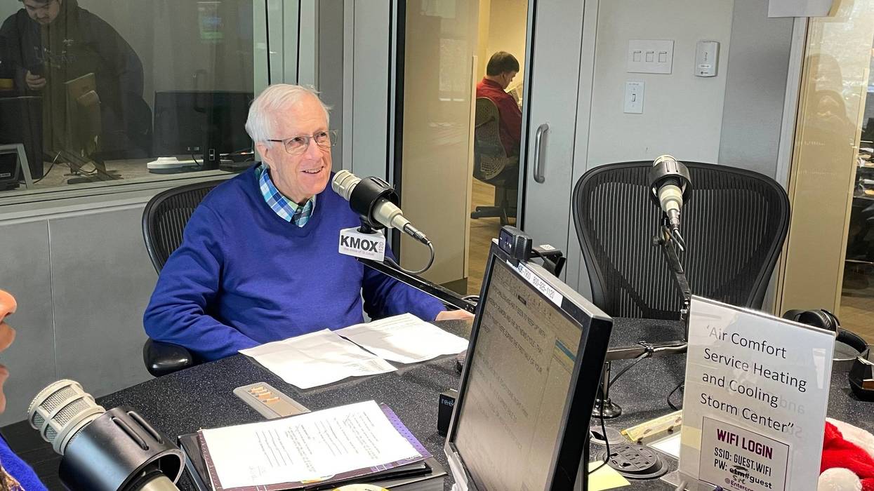 Rick Hummel sits in KMOX studio. he is a white man with white hair and a blue sweater on