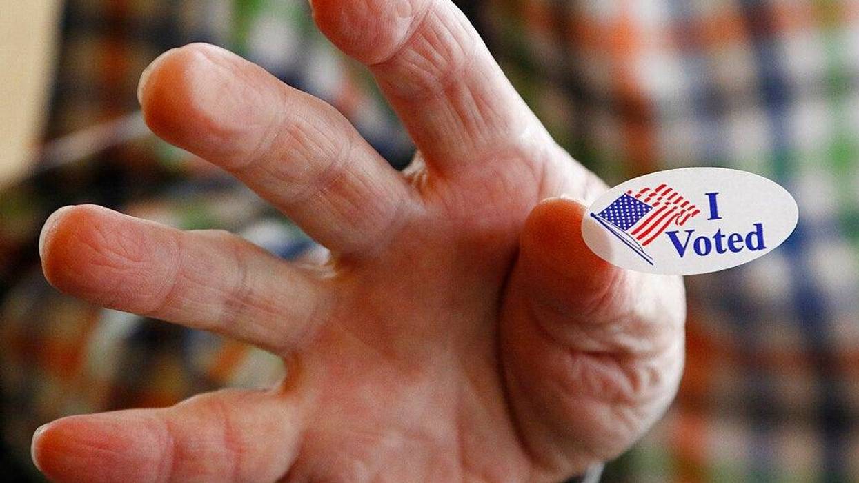 Ridgeland, Miss., precinct worker Cliff Smith offers people a "I Voted" sticker as they exit after voting in the party presidential primary, Tuesday, March 10, 2020.