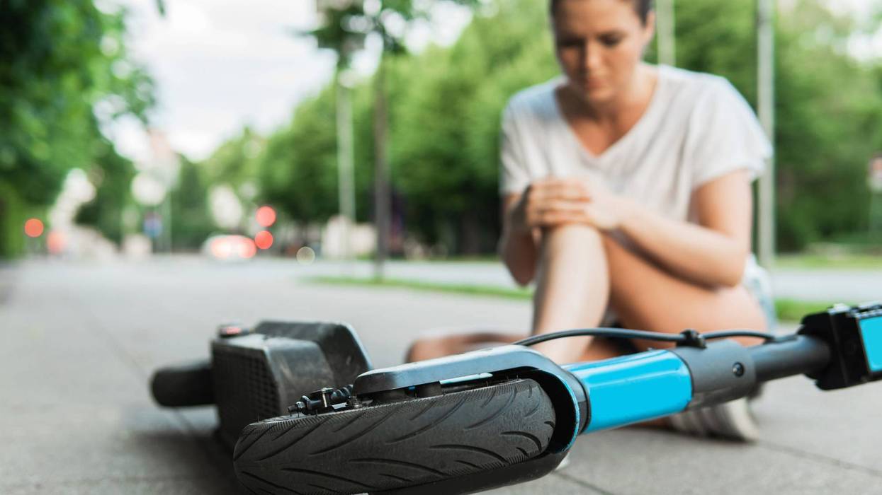 Riding electric scooters in bike lane past traffic jam