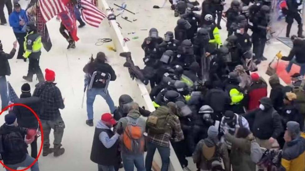 Robert Sanford is seen on video throwing a fire extinguisher into a group of police officers during the riots at the Capitol on Jan. 6, 2021.