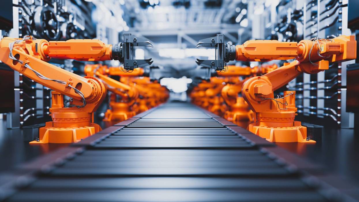 Robotic arms along assembly line in modern factory.
