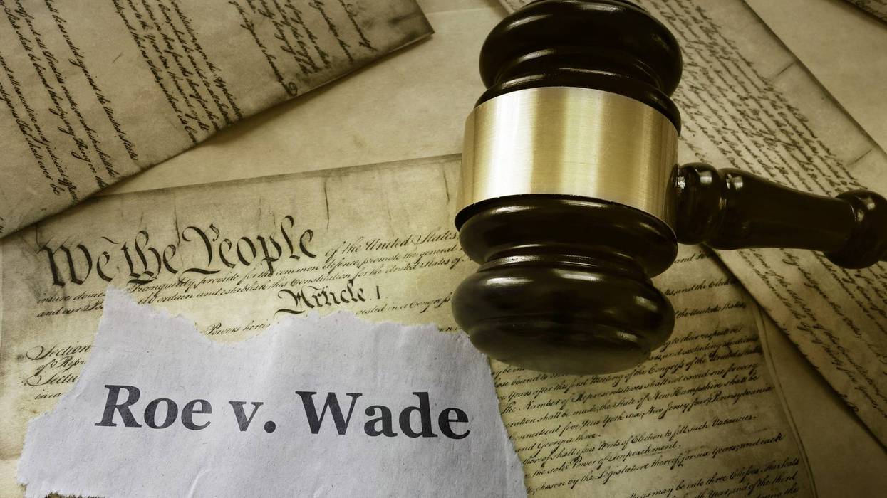 Roe v Wade news headline with gavel on a copy of the United States Constitution