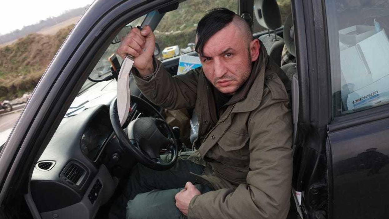 Roman, 35, a Ukrainian living in Poland, displays his knife as he waits to cross into Ukraine to join the armed resistance against the Russian invasion at the Medyka border crossing on March 04, 2022 in Medyka, Poland. In a report issued by the Ukrainian army stating the creation of a foreign legion unit for international volunteers, Ukraine's President Zelensky appealed to foreign nationals to join his army in the fight against Russia. On February 24, 2022 Russia began a large-scale attack on Ukraine, besieging its major cities. (Photo by Sean Gallup/Getty Images)