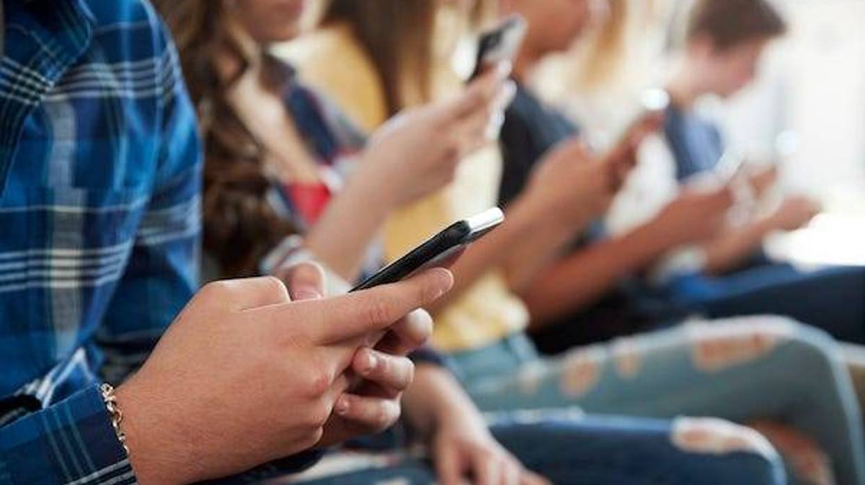 Row of high school students on their cellphones