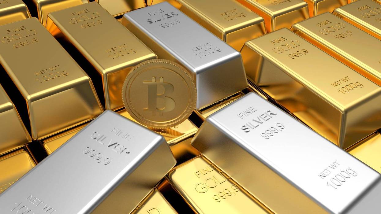 Rows of gold bars with bitcoin coin and silver bars