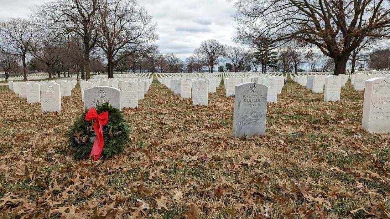 rows of graves, one wreath in front of one