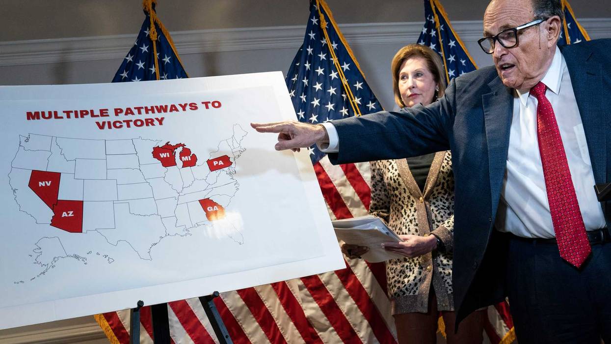 Rudy Giuliani points to a map as he speaks about various lawsuits related to the 2020 election alongside Sidney Powell.