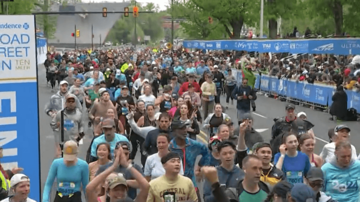 Runners cross the Broad Street Run finish line on Sunday.