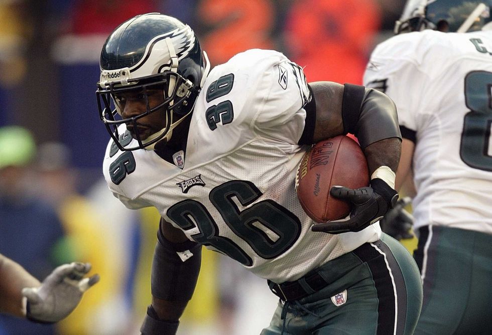 Running back Brian Westbrook of the Philadelphia Eagles steps over a New York Giant defender at Giants Stadium on Oct. 19, 2003 in East Rutherford, New Jersey. The Eagles defeated the Giants 14-10.