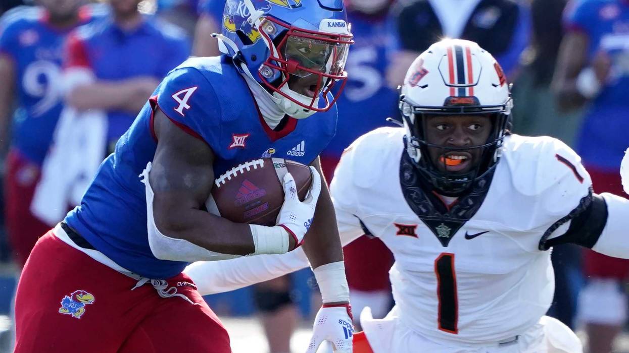 Running back Devin Neal #4 of the Kansas Jayhawks runs against linebacker Xavier Benson #1 of the Oklahoma State Cowboys in the first half at David Booth Kansas Memorial Stadium on November 5, 2022 in Lawrence, Kansas.