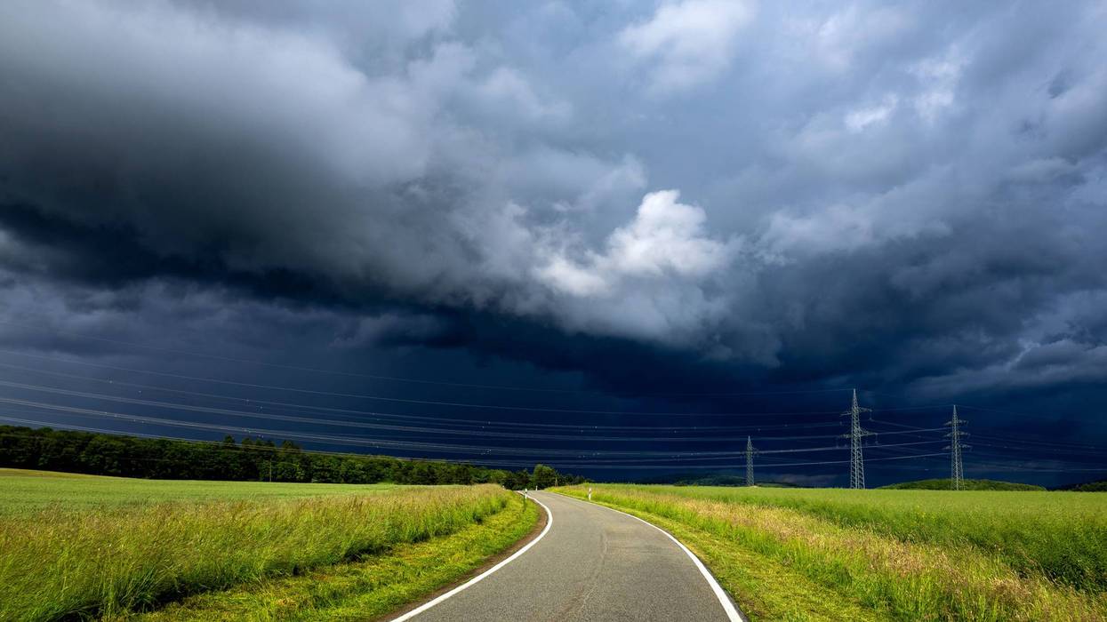 Rural road under dramatic storm clouds