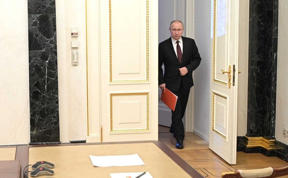 Russian President Vladimir Putin arrives at a meeting with members of Russia
