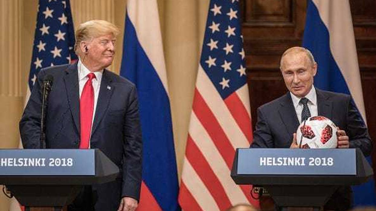 Russian President Vladimir Putin hands U.S. President Donald Trump (L) a World Cup football during a joint press conference after their summit on July 16, 2018 in Helsinki, Finland.