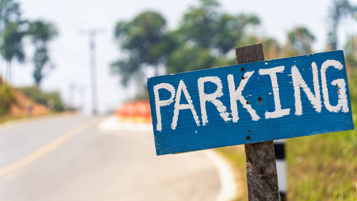 Rustic parking sign on rural roadside in Thailand