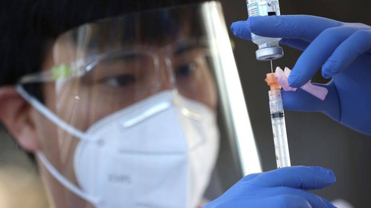 Safeway pharmacist Preston Young fills a syringe with Moderna COVID-19 vaccination during a drive-thru COVID-19 vaccination clinic at the Sonoma County Fairgrounds on January 13, 2021 in Santa Rosa, California.