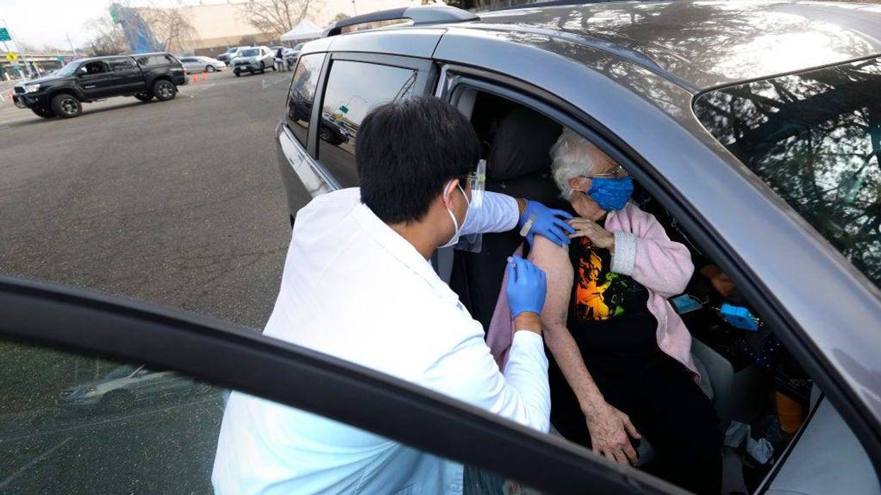 Safeway pharmacist Preston Young (L) administers a Moderna COVID-19 vaccination to Cecile Lusby (R) during a drive-thru COVID-19 vaccination clinic at the Sonoma County Fairgrounds on January 13, 2021 in Santa Rosa, California. Sonoma County health workers received COVID-19 vaccinations during a drive-thru clinic that was hosted by Sonoma County and Safeway.