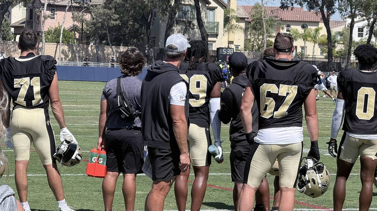 Saints defensive players in alternate jerseys stand during a joint practice with the Cowboys.