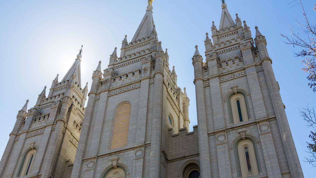 Salt Lake City LDS Mormon Temple spires with sun lighting it from behind.