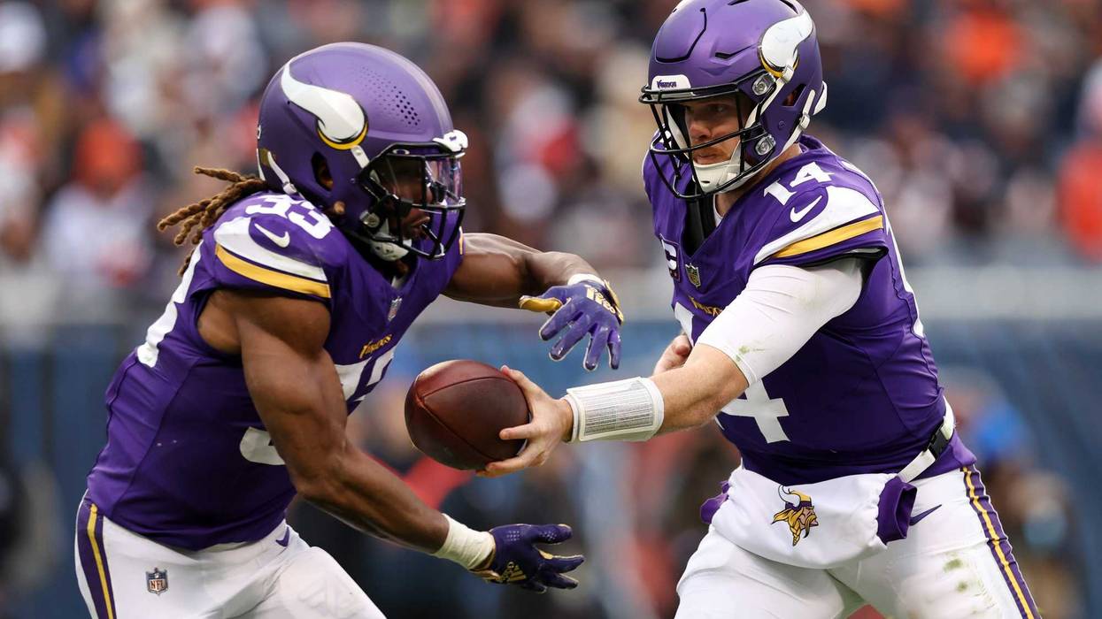 Sam Darnold #14 of the Minnesota Vikings hands off to Aaron Jones #33 during the third quarter against the Chicago Bears at Soldier Field on November 24, 2024 in Chicago, Illinois.