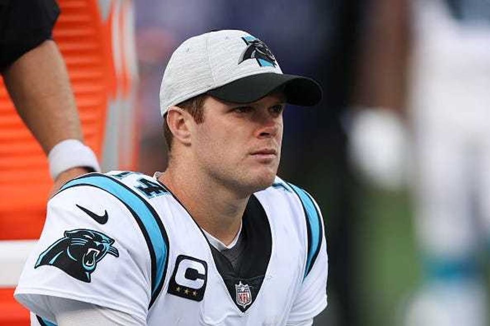 Sam Darnold watches from the Panthers sideline