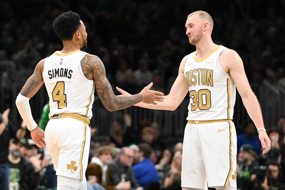 Sam Hauser #30 of the Boston Celtics reacts with Anfernee Simons #4 after scoring a basket against the Miami Heat during the second half at the TD Garden on December 19, 2025 in Boston, Massachusetts.
