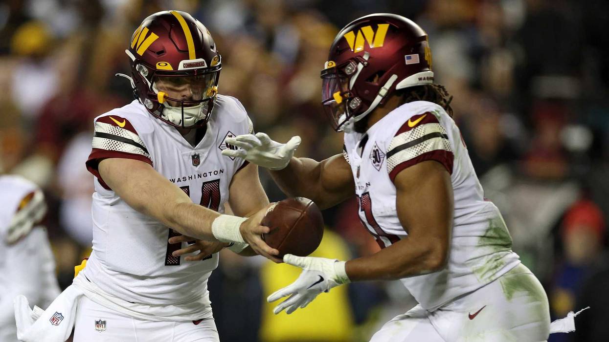 Sam Howell hands the ball off to Jonathan Williams during a Washington Commanders game in 2023.