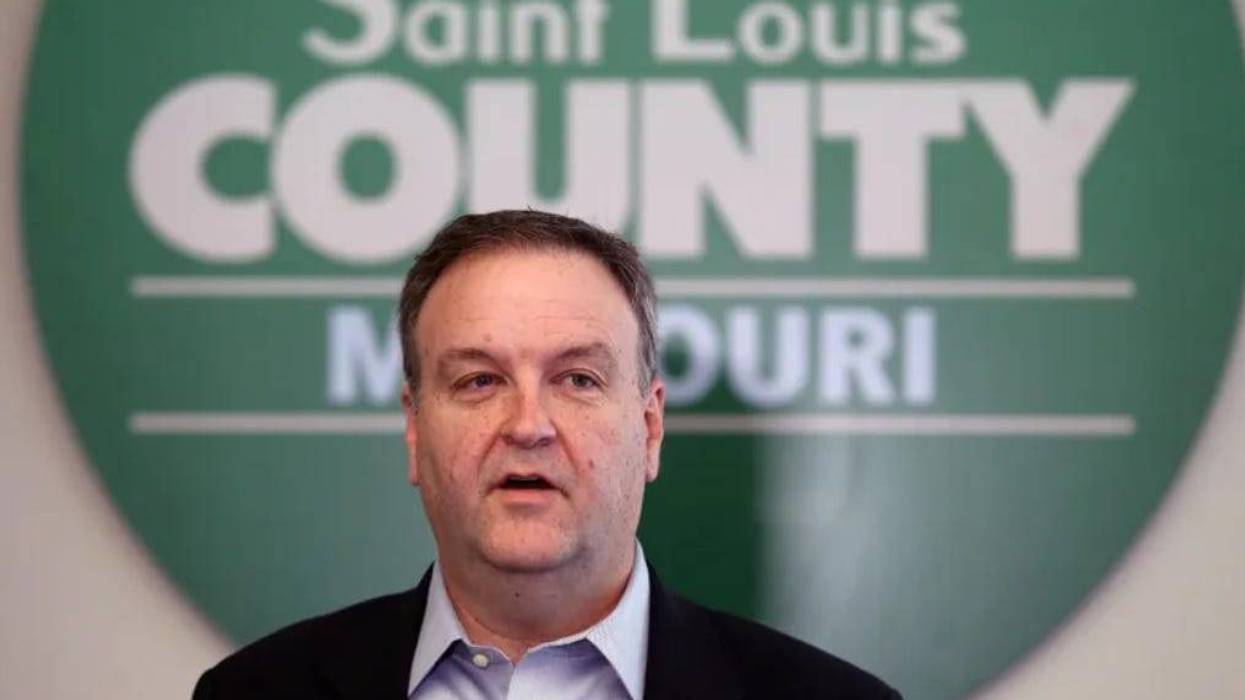 Sam Page stands in front of a green sign.