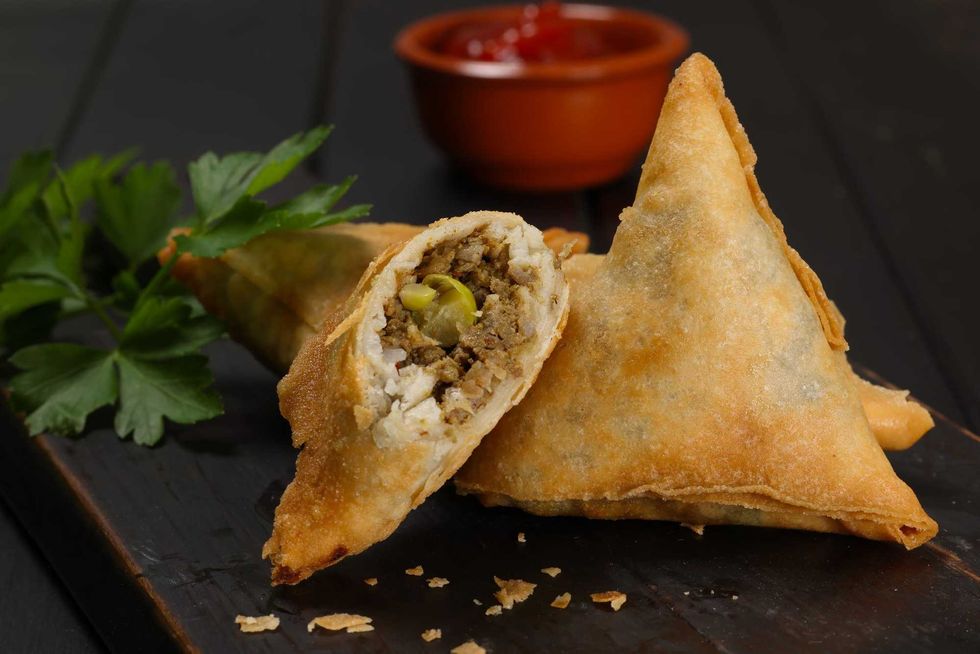 Samosa is a fried or baked pastry with a savoury filling, including spiced potatoes, onions, peas, chicken and/or other meats.