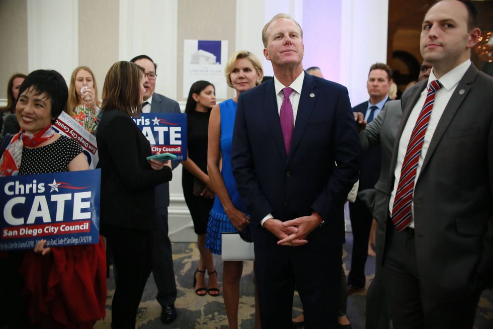 San Diego Mayor Kevin Faulconer, middle, listens to speakers during an election eve party at the U.S. Grant Hotel in San Diego, California on Tuesday, June 5, 2018.