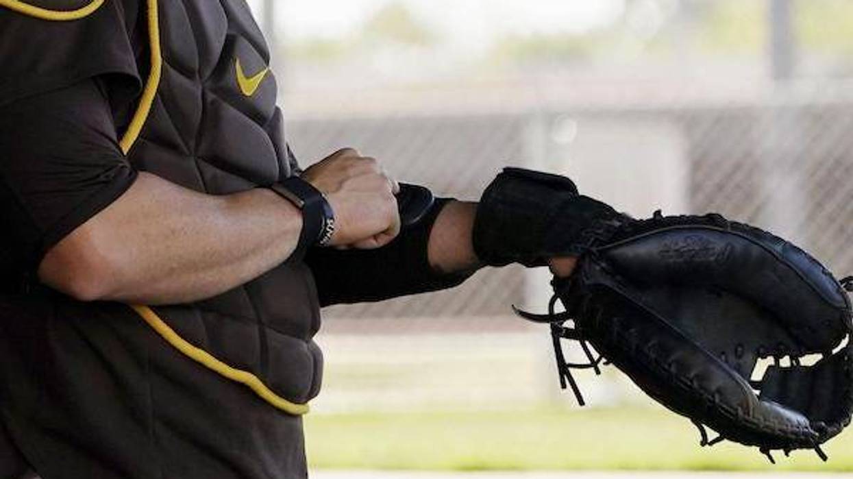 San Diego Padres catcher Victor Caratini tests a device used to call pitches, Pitchcom